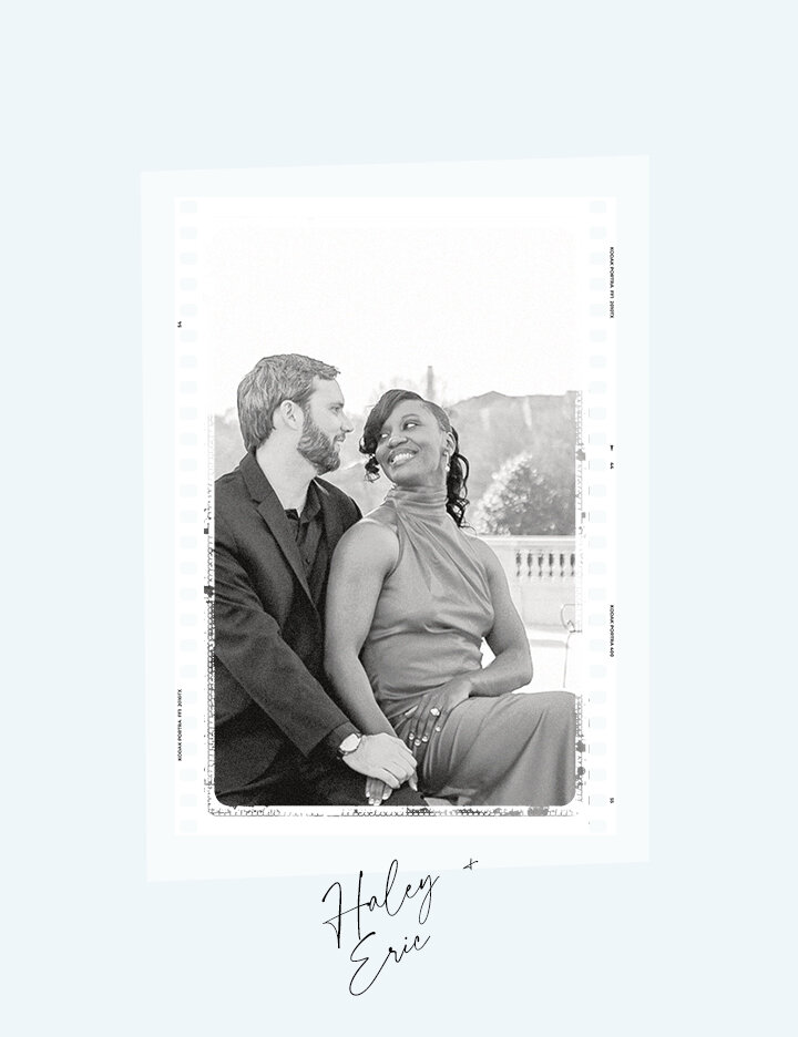 A black and white engagement portrait of Haley and Eric holding hands and smiling at each other, sitting outdoors with a balustrade in the background.