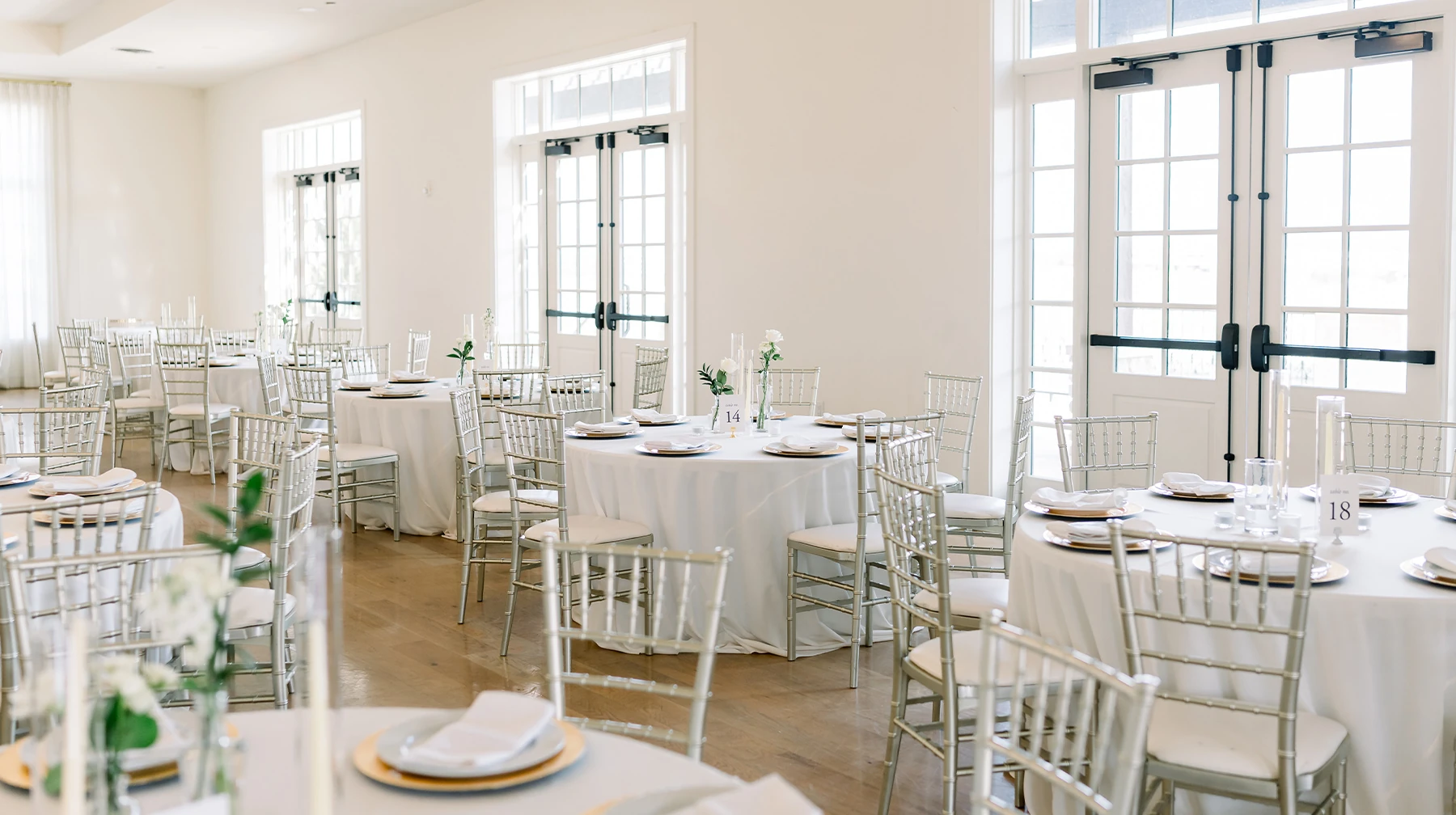 Elegant stone chapel with arched windows and terracotta roof surrounded by water at a waterfront wedding venue