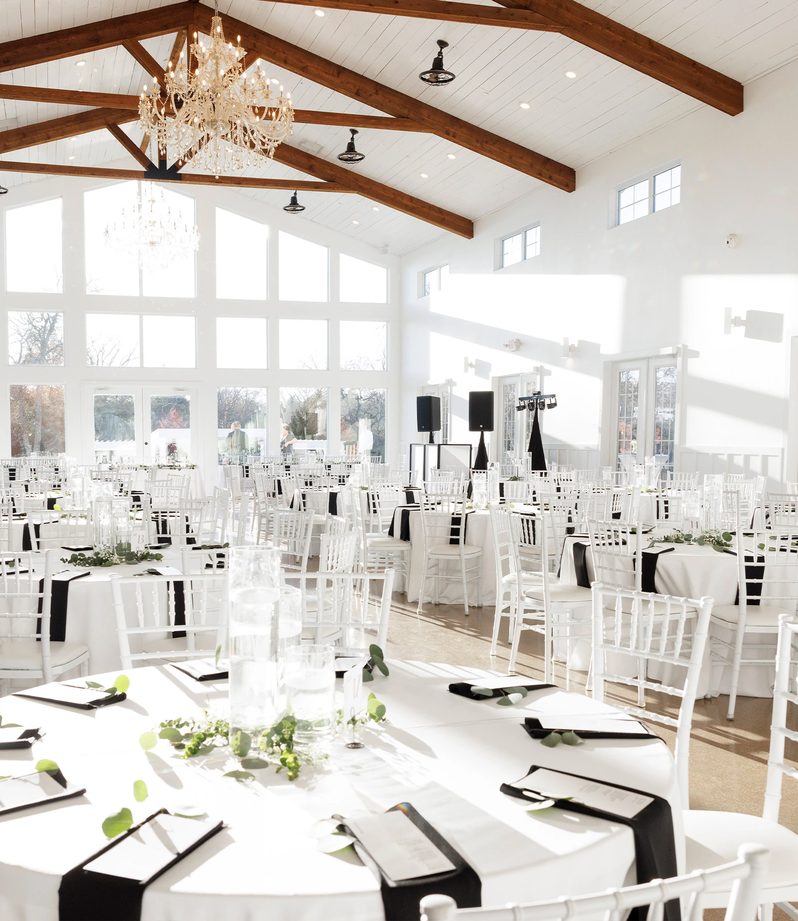 Scenic outdoor view of a pond with a white bridge, surrounded by lush green lawns and trees at a wedding venue