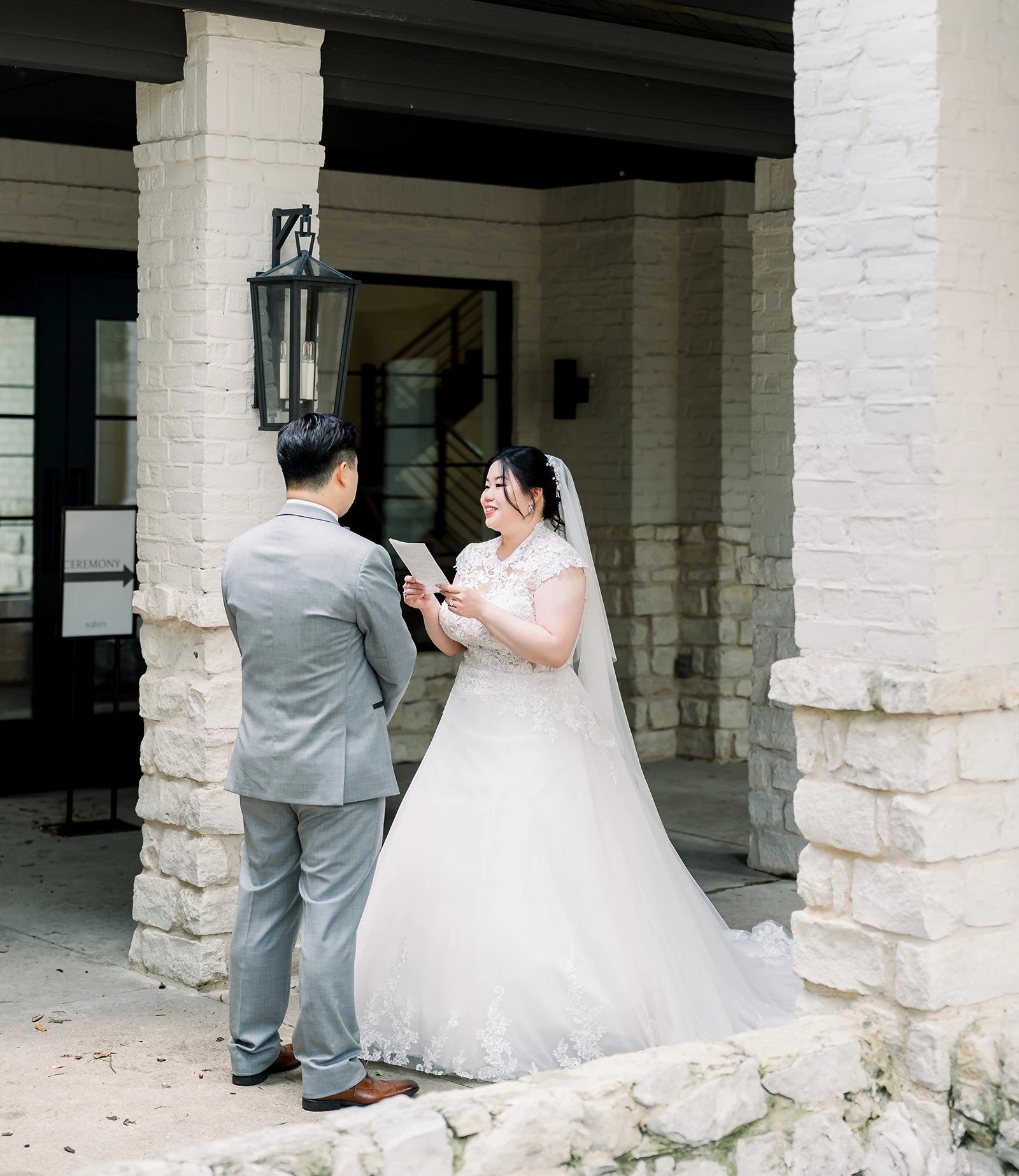 Garden area outside a stone wedding venue with large arched windows, shaded lawn, and a floral-decorated swing hanging from a tree