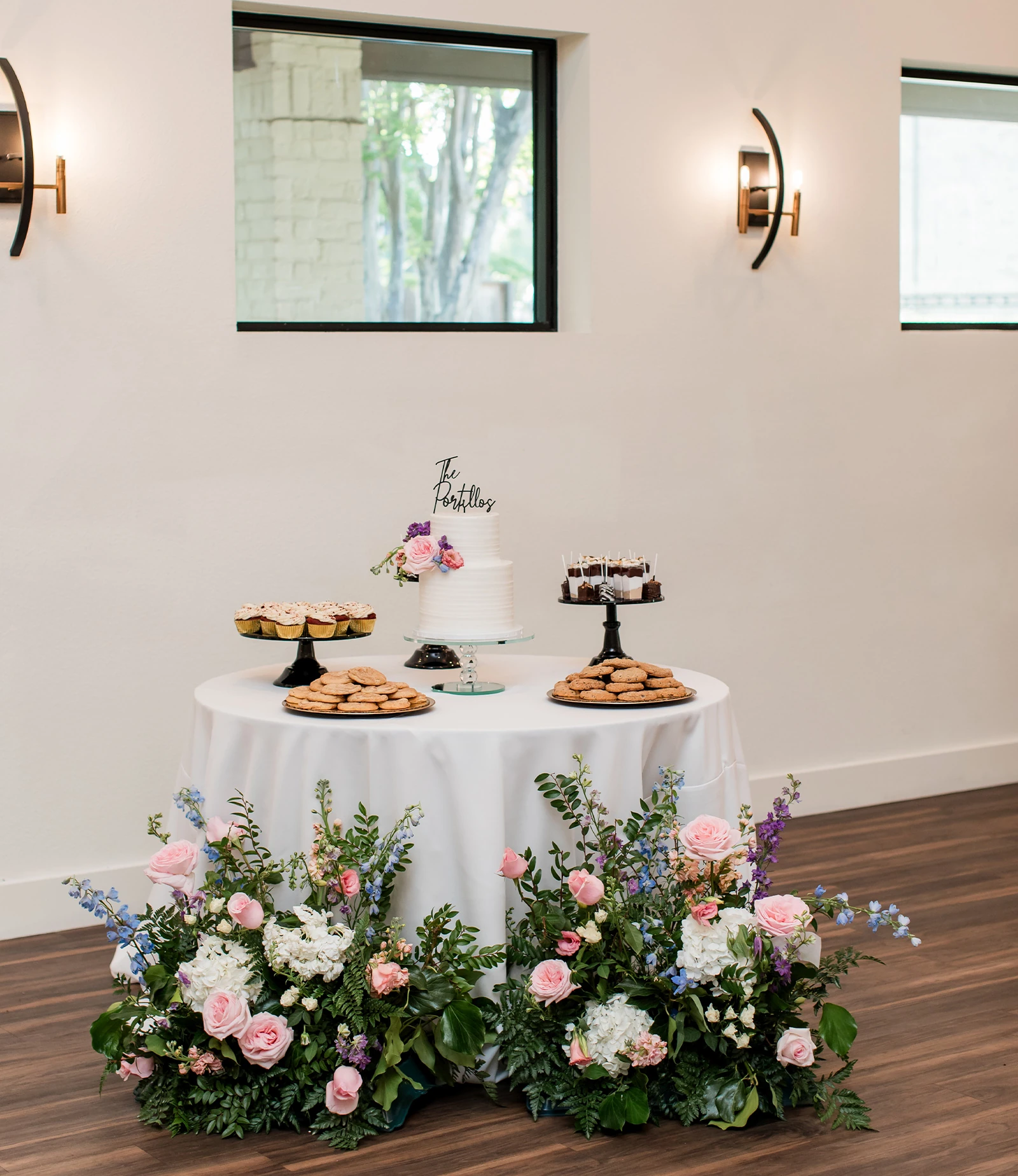 Covered stone entryway at Hayes Hollow venue with black double doors, lantern sconces, and surrounding trees