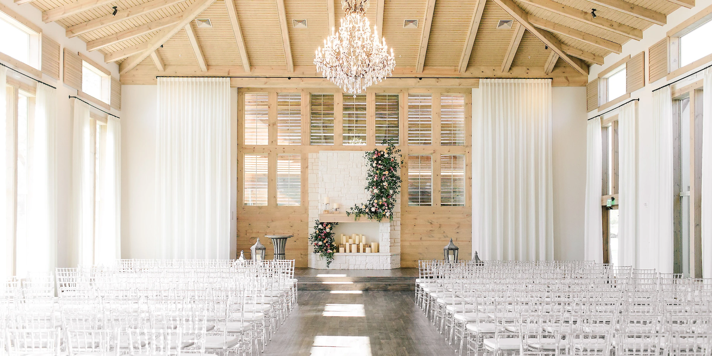 Decorated interior wedding ceremony space with chandeliers and flowers