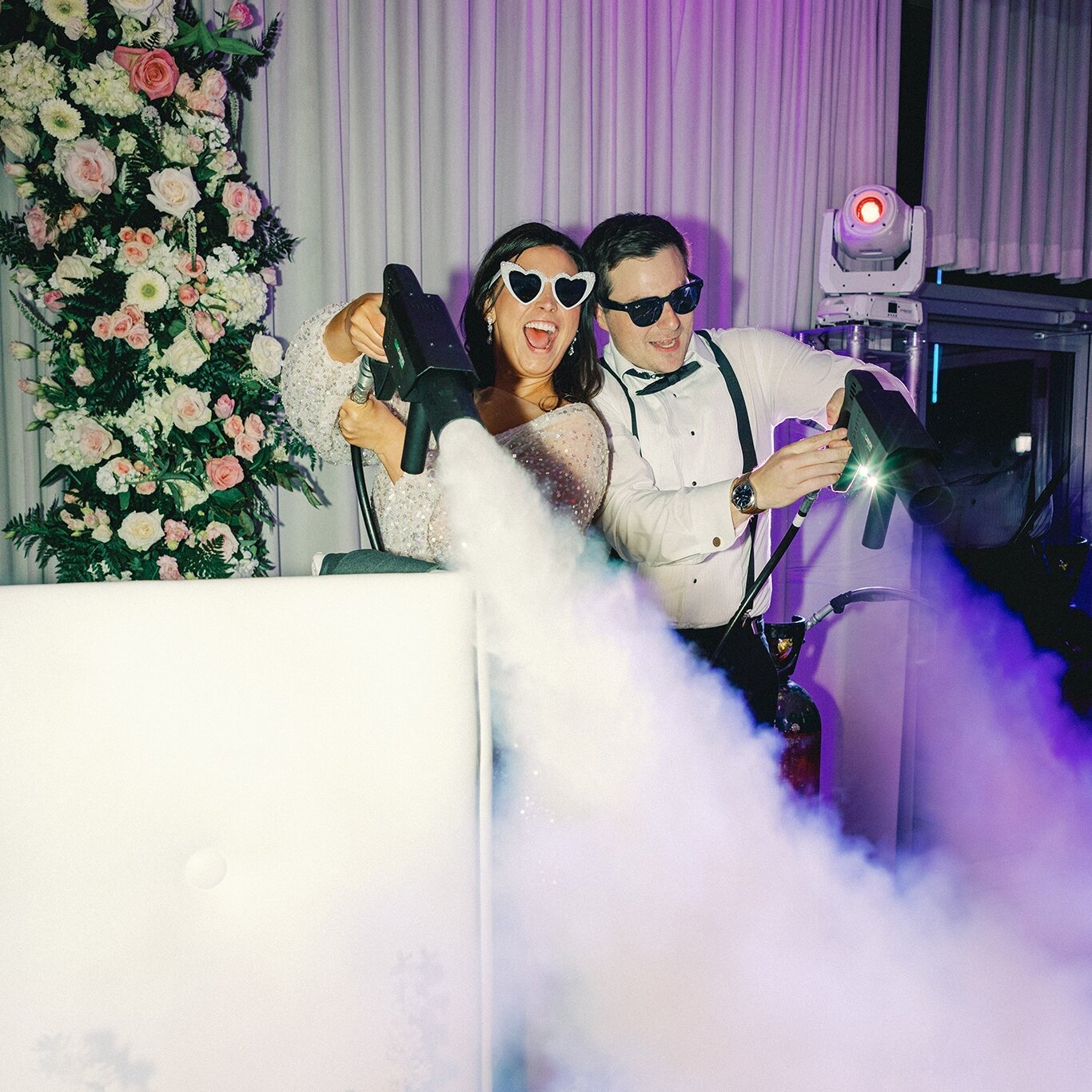 Bride and groom joyfully making their wedding grand exit with sparklers outside a rustic barn venue.