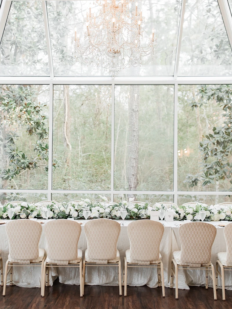 Bride and groom share a joyful first dance surrounded by soft clouds of fog in an elegant, light-filled reception space.