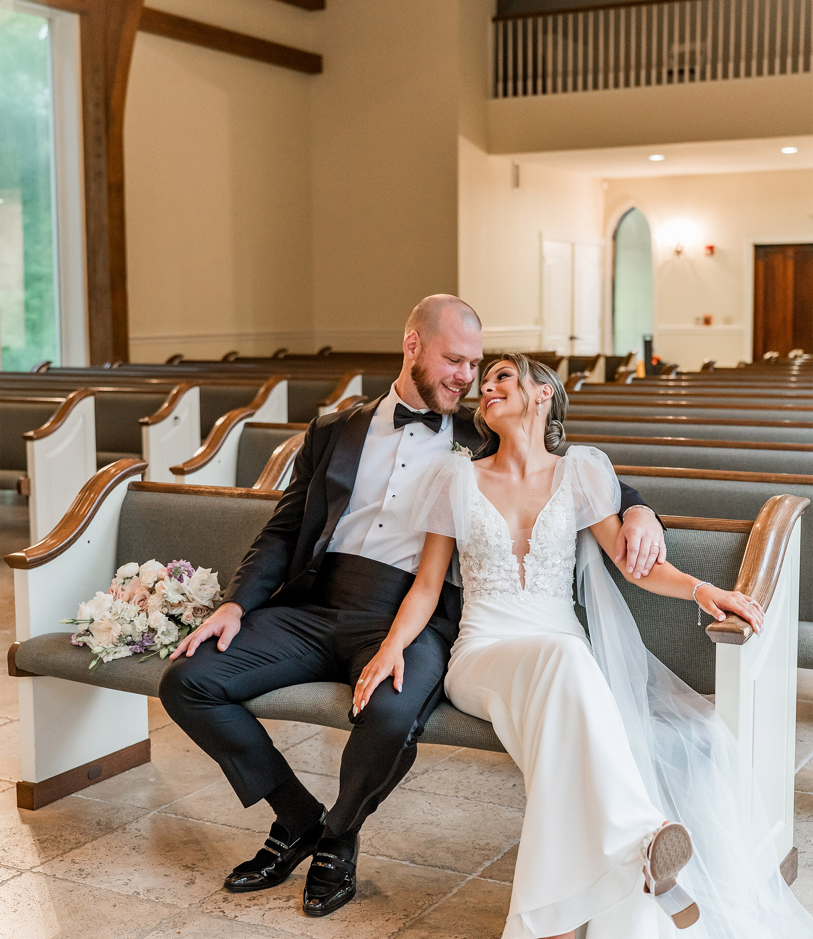 Just-married couple walking joyfully down the aisle as guests cheer during their chapel ceremony