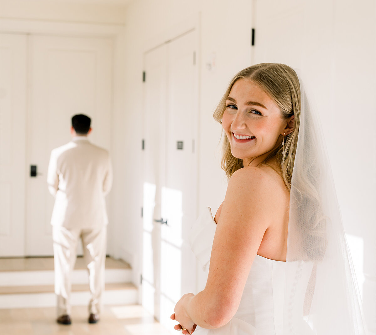 Bride holding colourful bouquet next to groom on a stone staircase with flower arrangements surrounding them