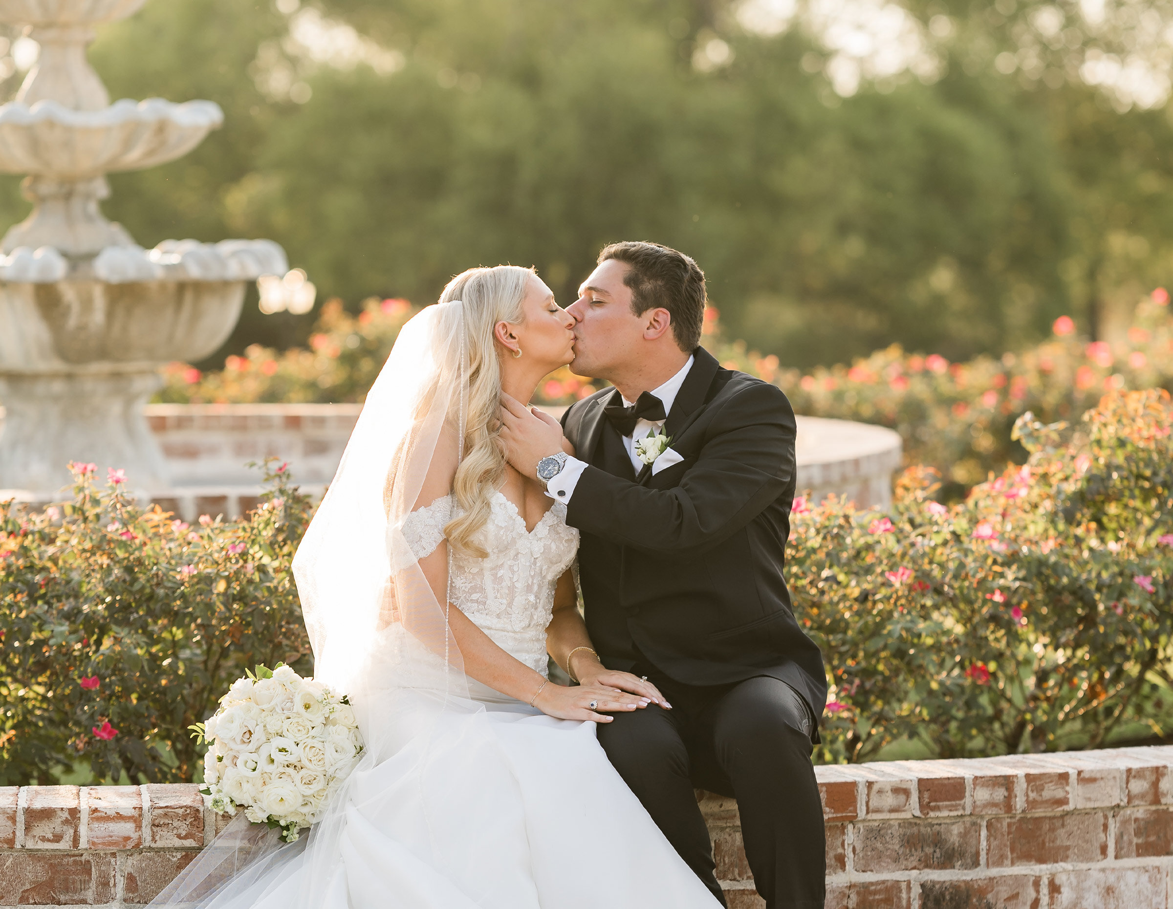 Two wedding photographers capturing the kiss of a bride and groom