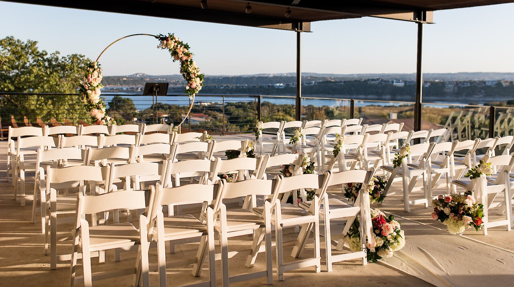 Exterior view of the Highland Lakes event center with modern architecture, stone accents, and a wooden pergola at the entrance