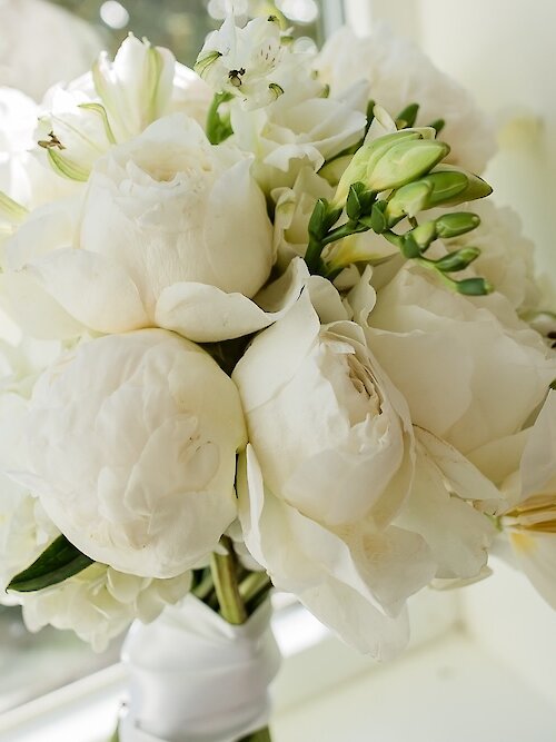 White flowered wedding bouquet in windowsill