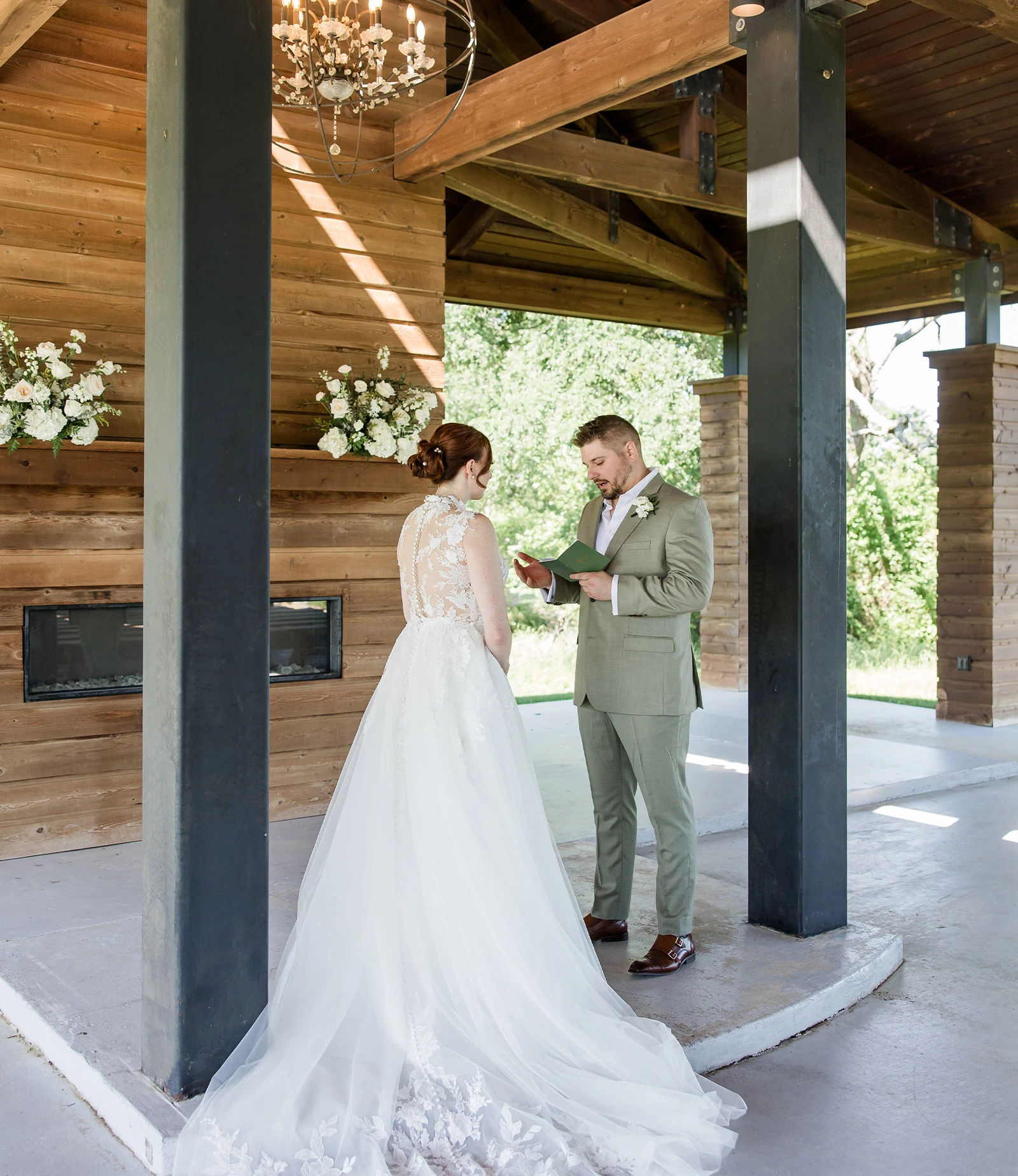 Elegant round reception table with black chiavari chairs, white linens, and floral centerpiece inside a wooden barn venue