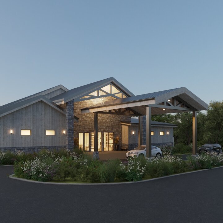 A rendered view of the modern rustic wedding venue exterior at dusk, featuring gray wood siding, a prominent stone entrance, and native landscaping around the driveway.