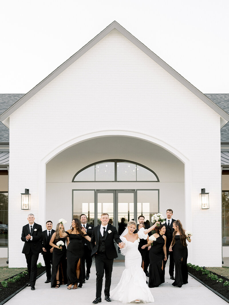 Rendering of the Aylin Acres foyer with high vaulted ceilings, large windows, crystal chandeliers, tall cocktail tables, and an arch decor piece with greenery.