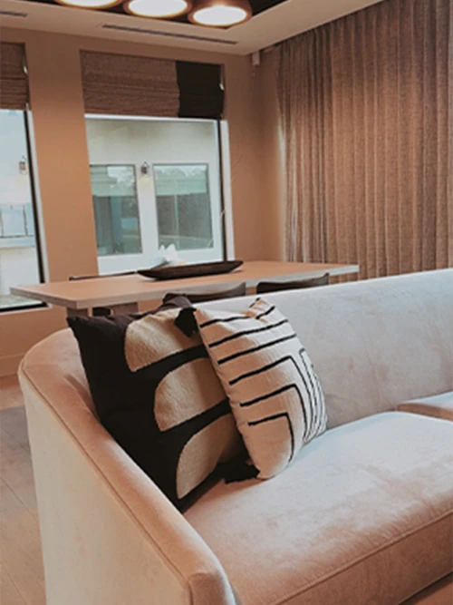 A rendered view of the luxurious bridal suite lounge area featuring modern gray seating, a crystal chandelier, a refreshment bar, and a makeup vanity area visible in the background.