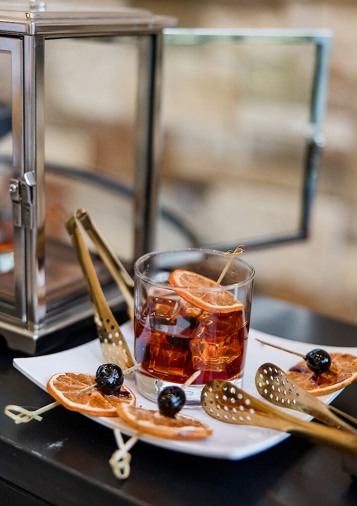 A close-up of a tiered champagne tower full of flutes of bubbly, set up outside near large, illuminated marquee letters.