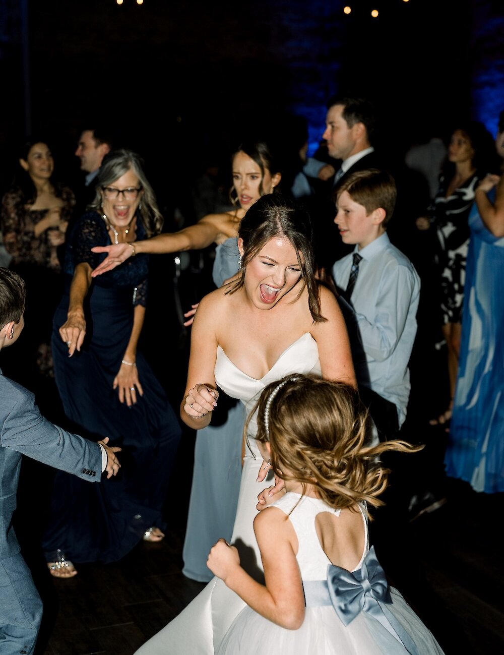 A joyful bride and groom exiting the ceremony aisle after their wedding, holding hands as guests applaud.