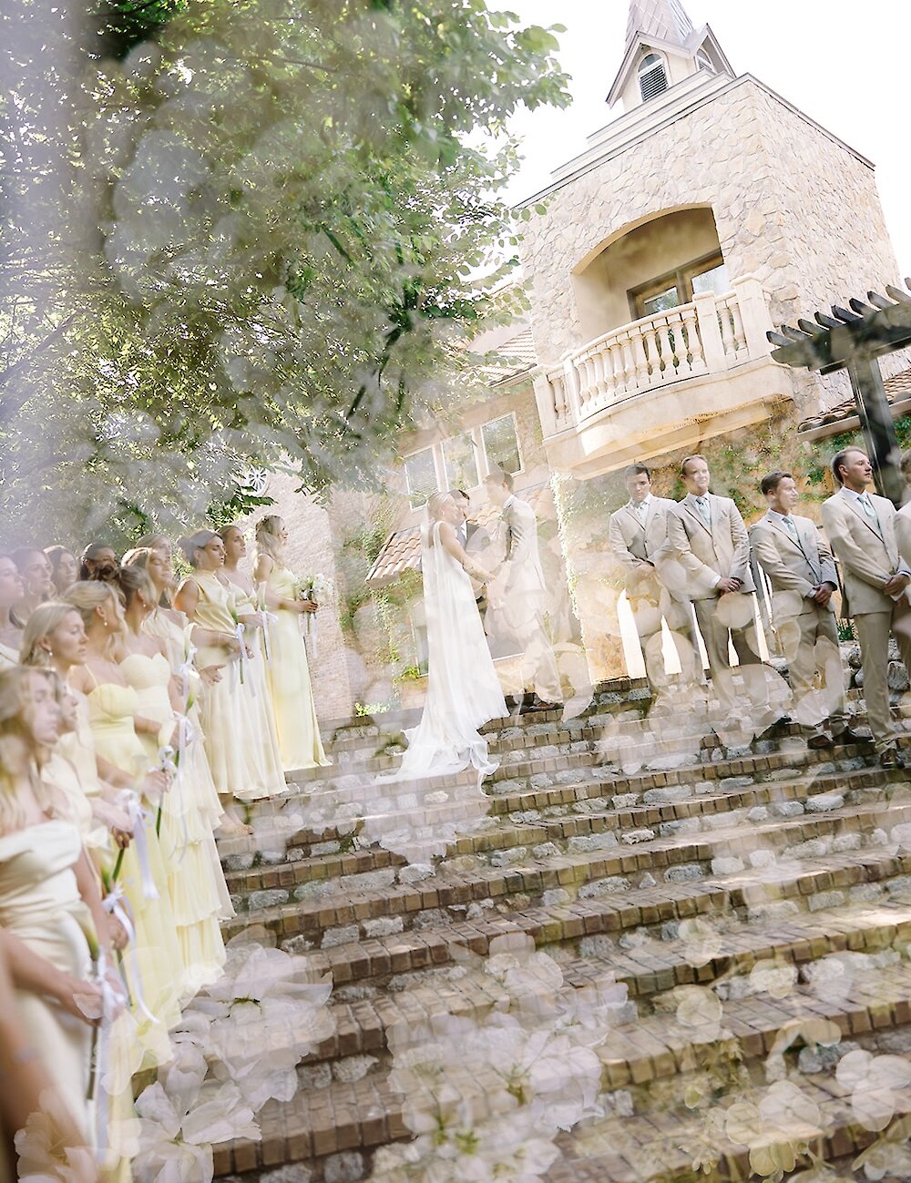 A creative double exposure image of an outdoor wedding ceremony on stone stairs and light-colored floral details.