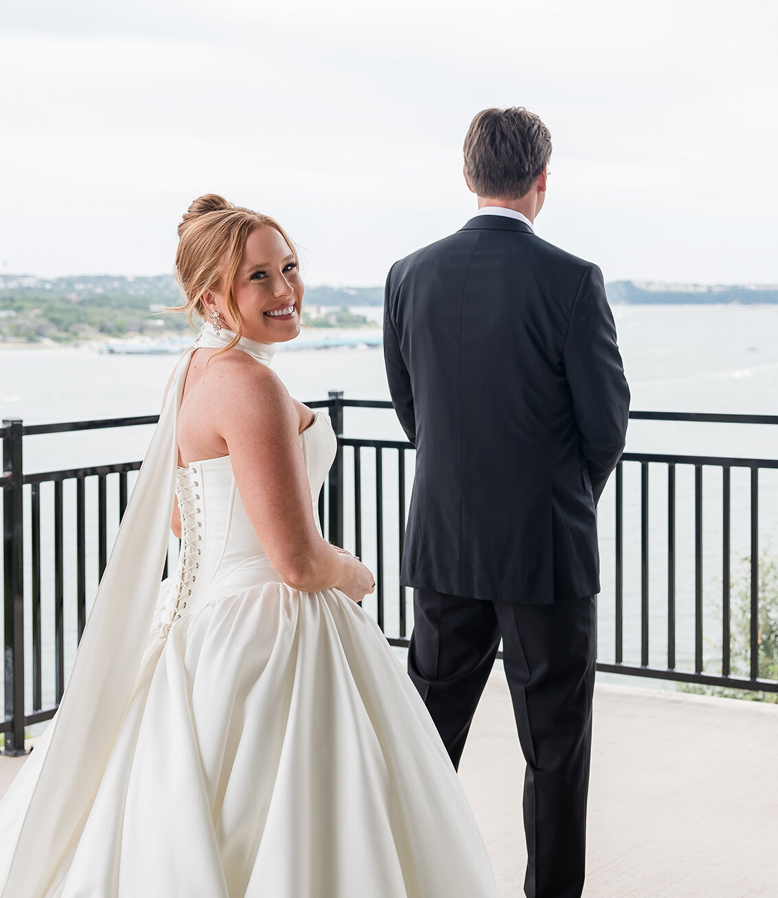 Bride and groom before a first look on the balcony with lake in the background