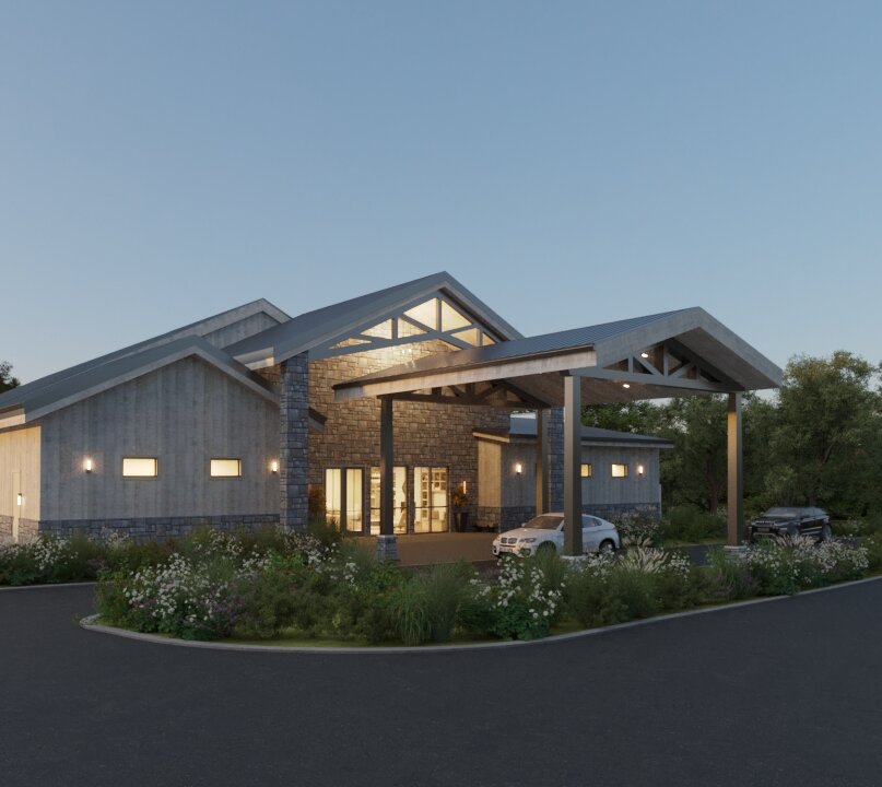 A rendered view of the modern rustic wedding venue exterior at dusk, featuring gray wood siding, a stone entrance, and a covered drive-up area with cars and wild landscaping.