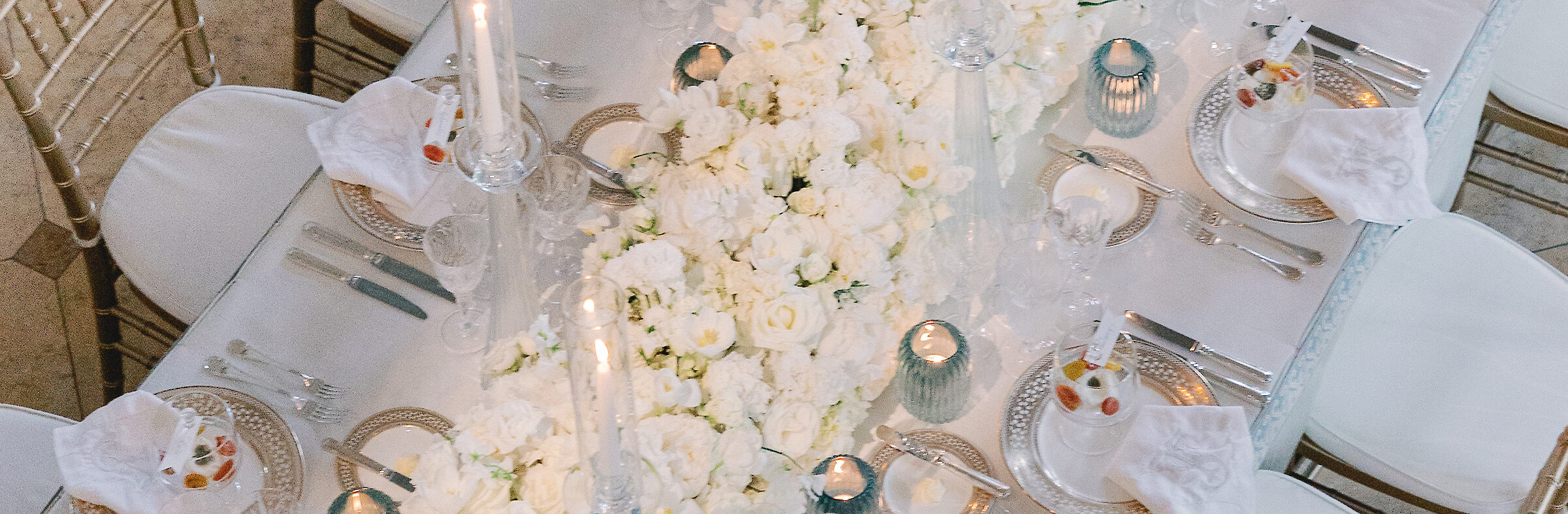 White bridal bouquet wrapped in transparent white veil.