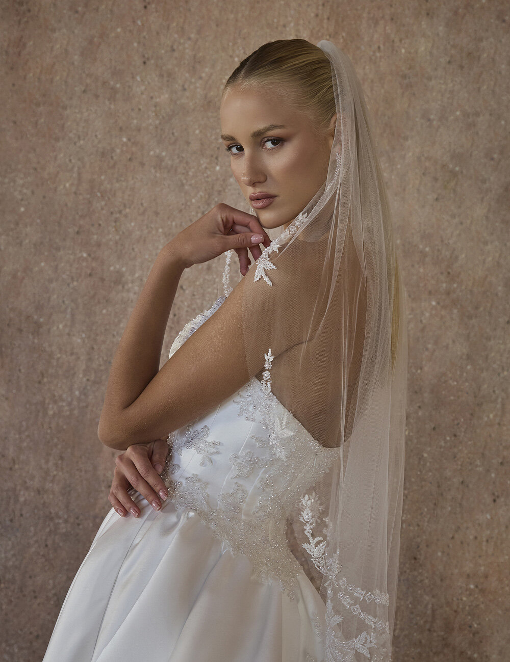 bride looking over shoulder and finger is on chin