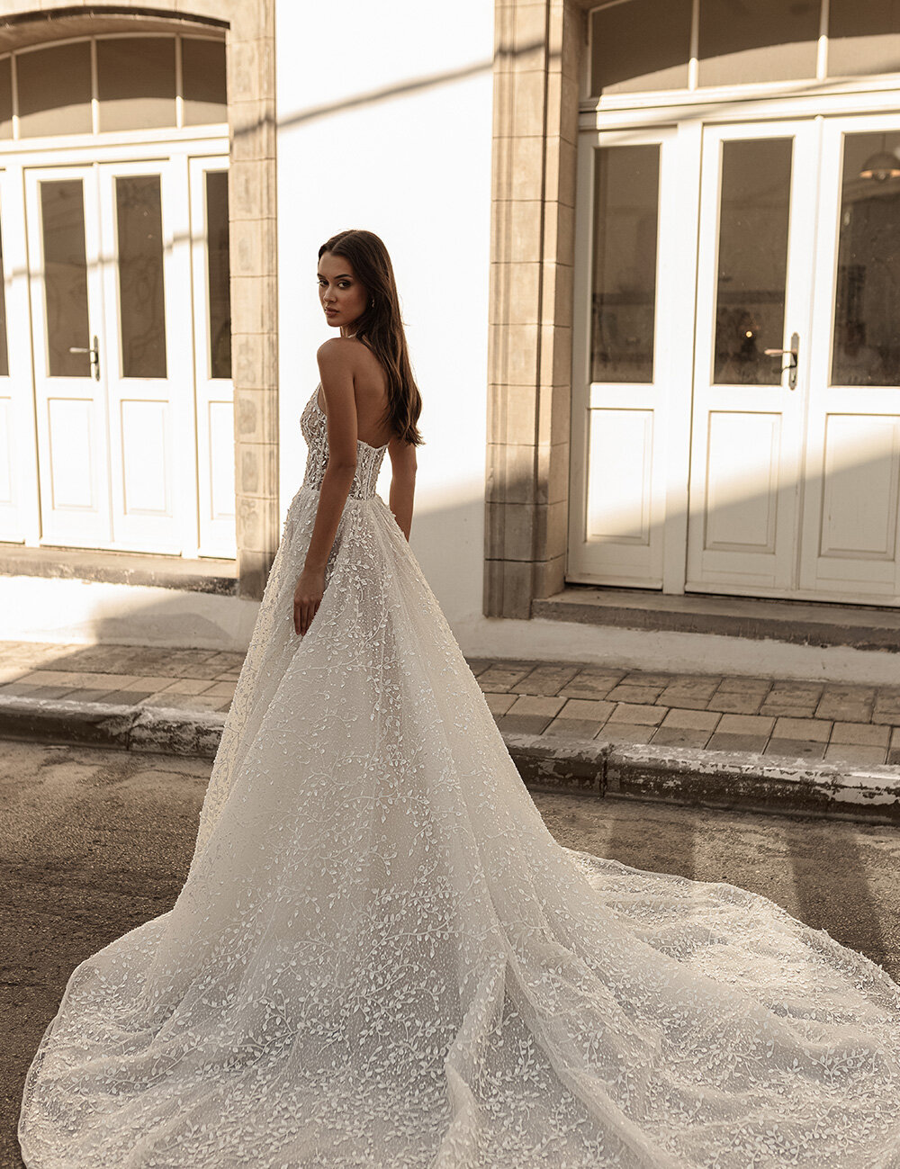 bride in big white gown outside looking over shoulder