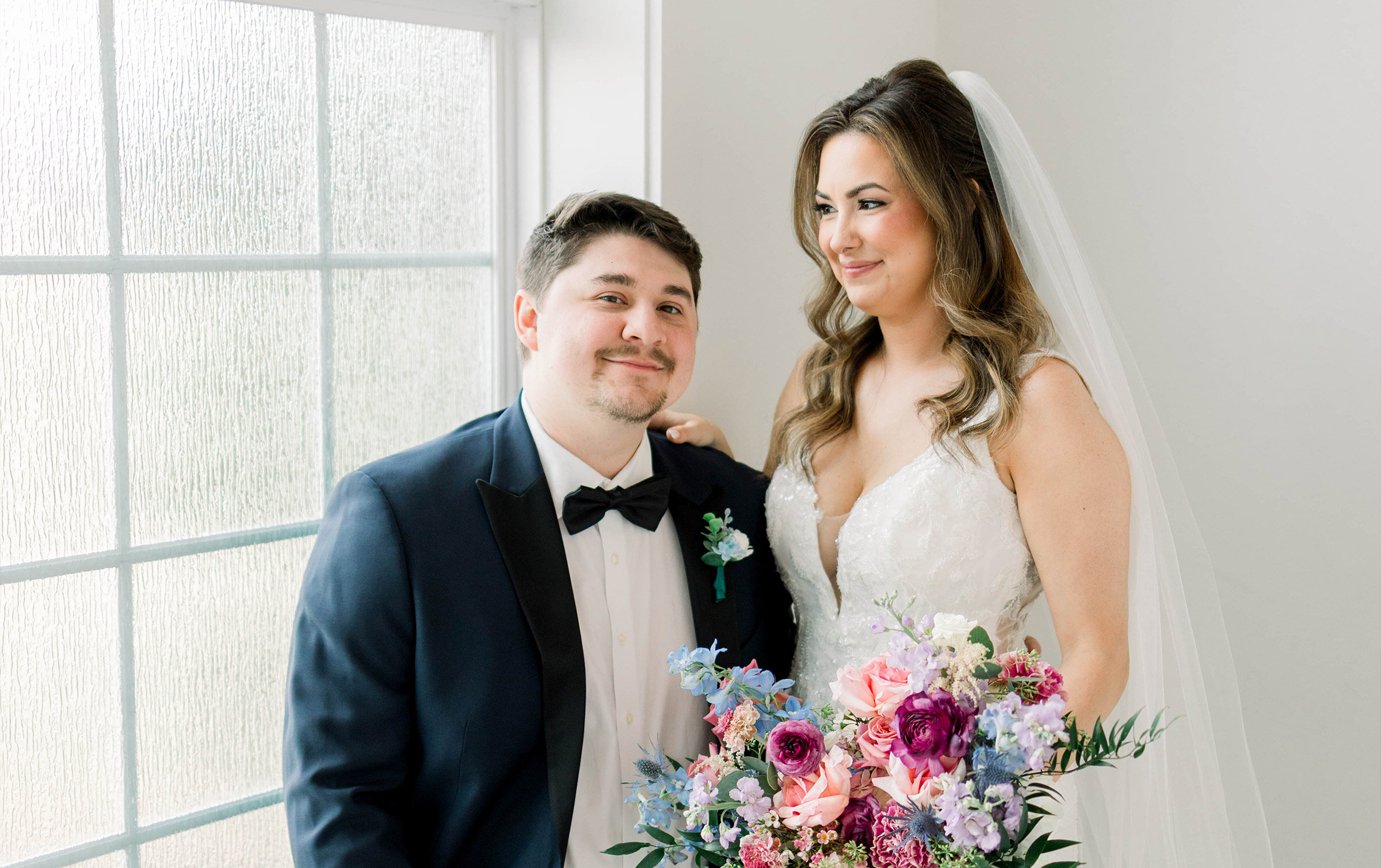 bride looking down and groom smiling