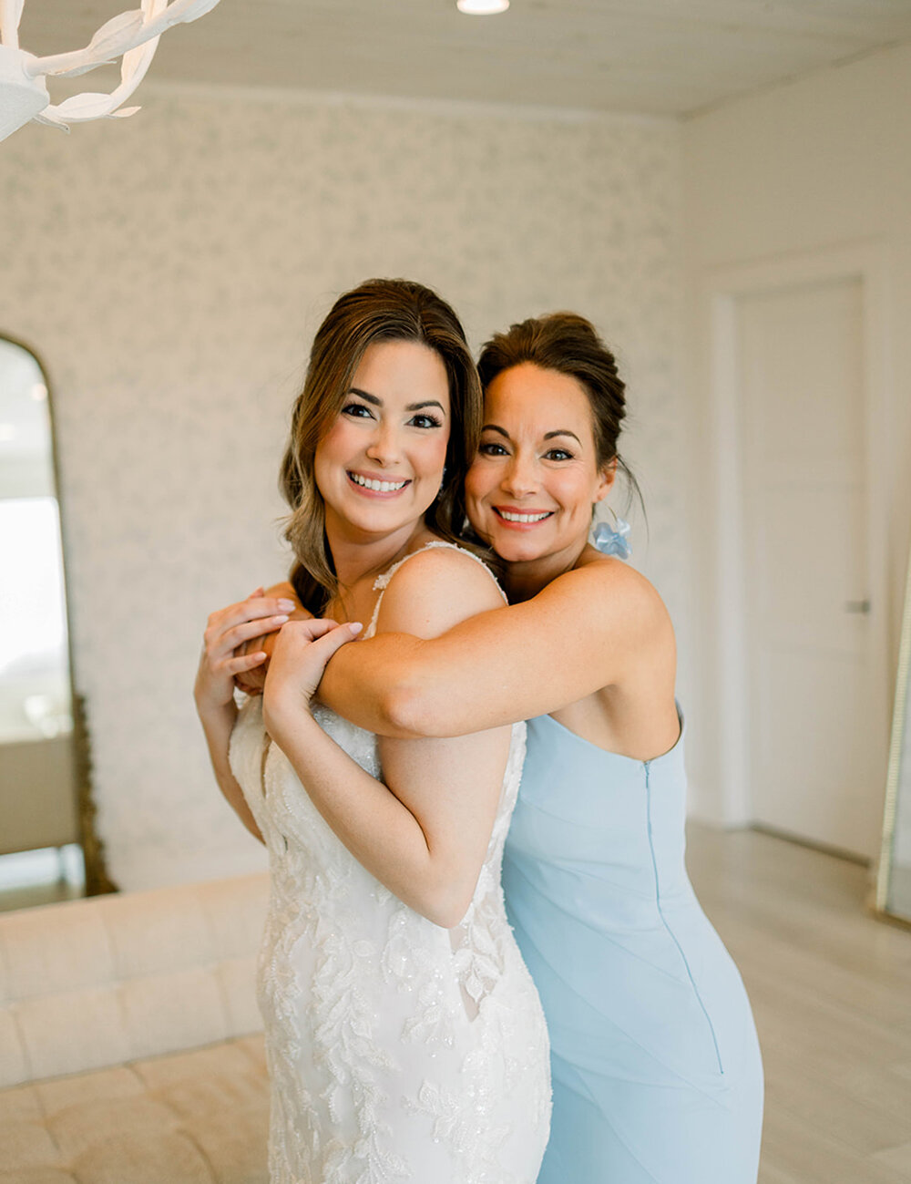 bride with mom hugging from back