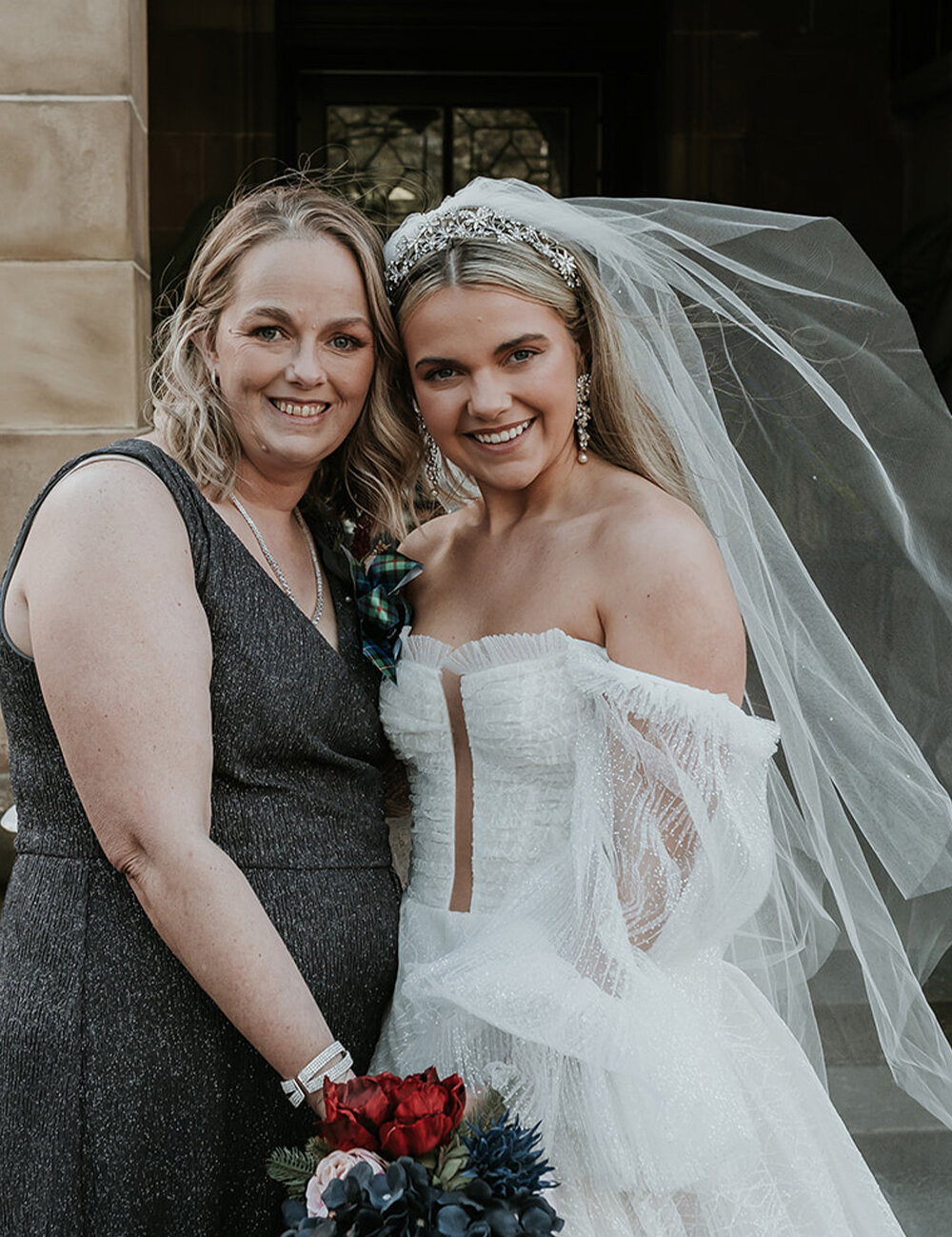 mother and bride outside smiling at camera