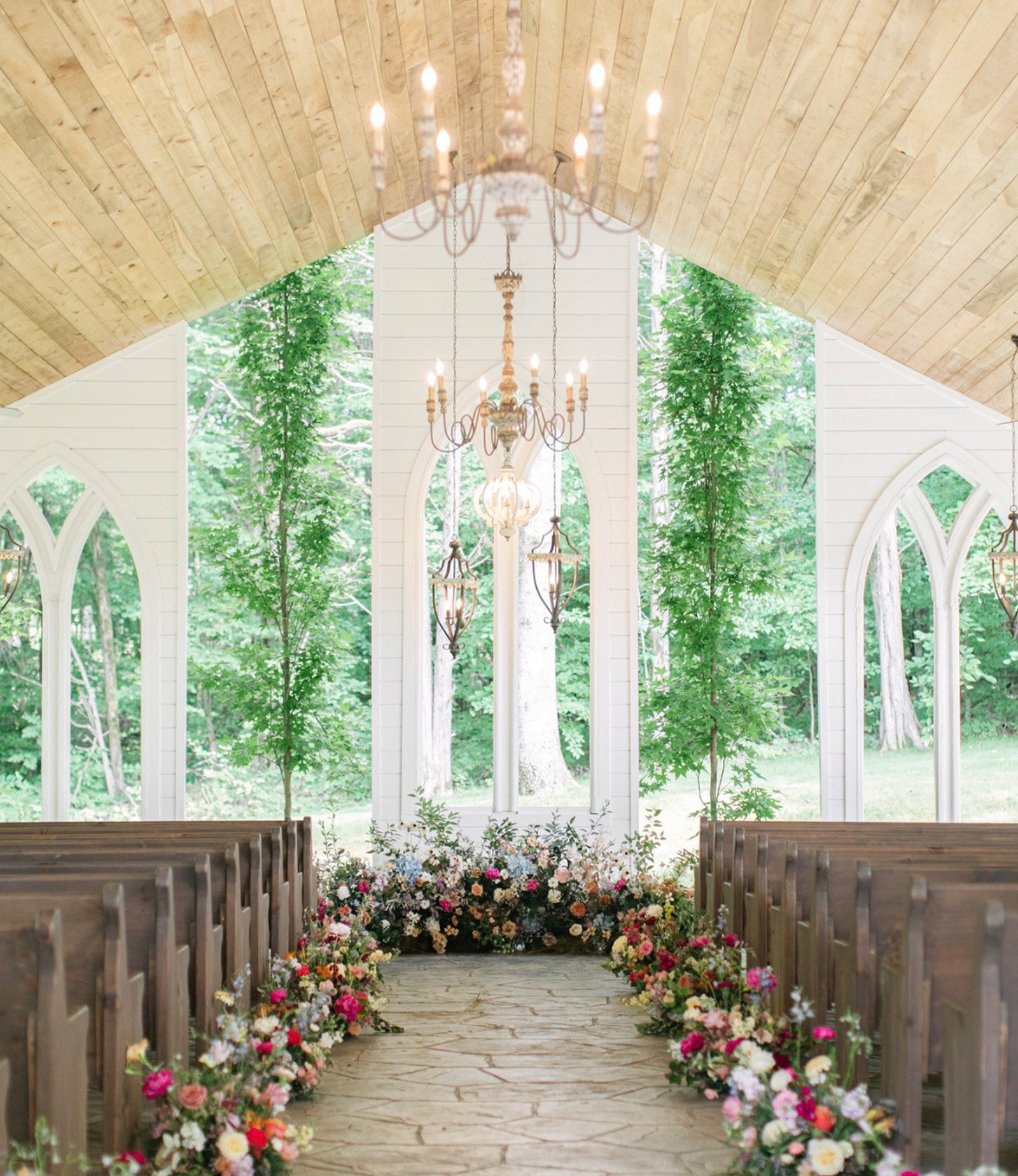 Open air wedding chapel with chandelier and floral decor