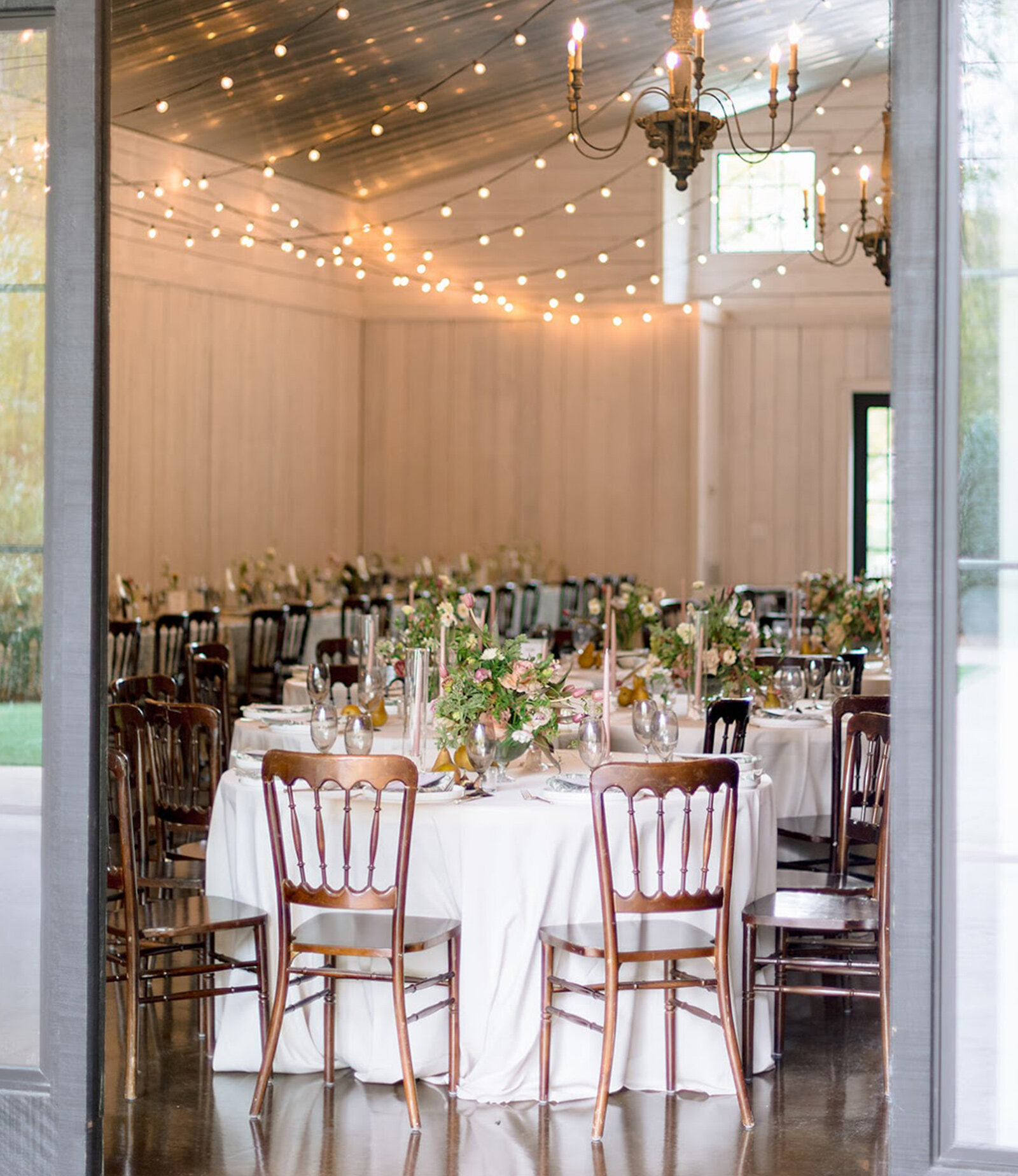Rustic reception hall with white walls and string lights