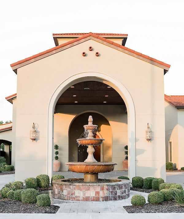 European-inspired stone building with terracotta roof tiles and a grand brick staircase.