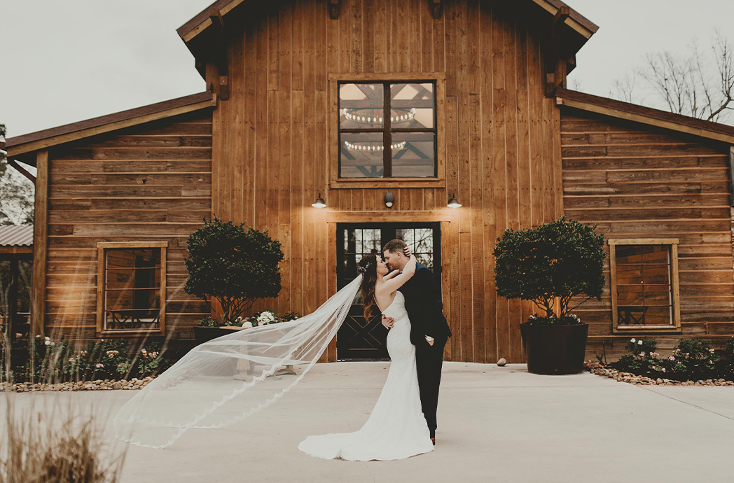 couple kissing outside barn