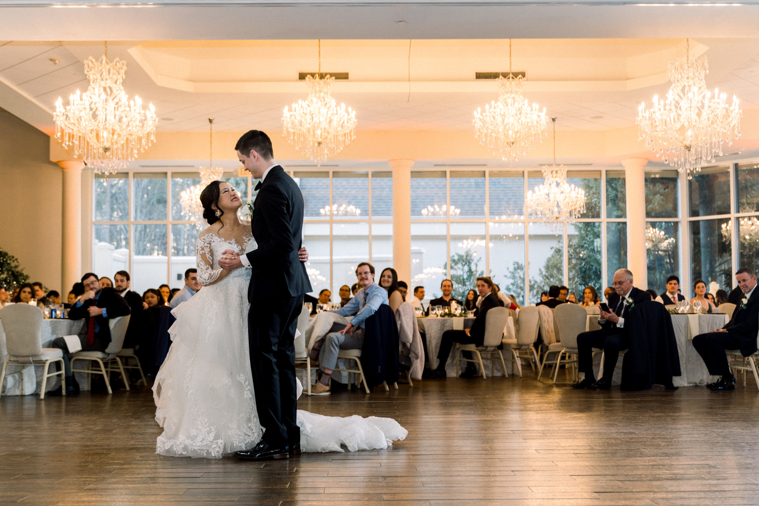 bride and groom first dance under chandeliers