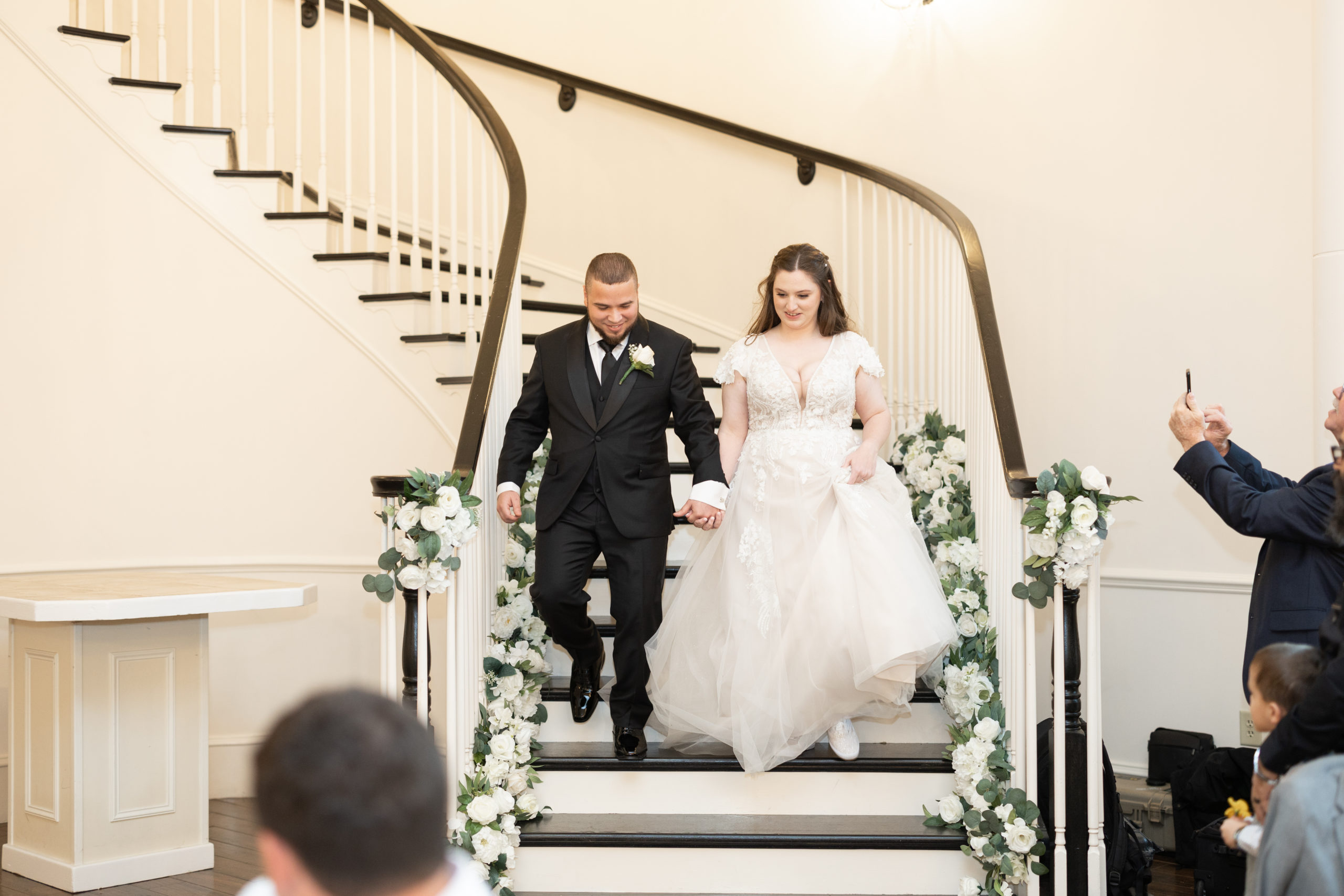 Bride and groom grand entrance down winding staircase