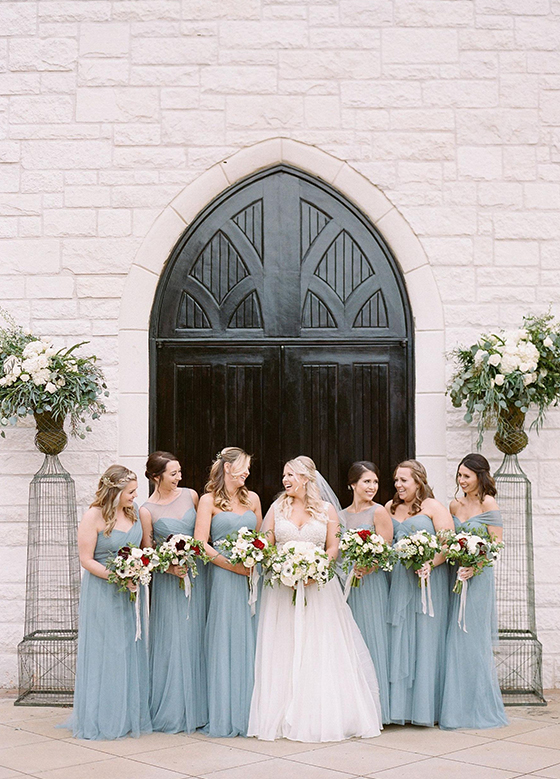Bride and bridal party in front of chapel doors