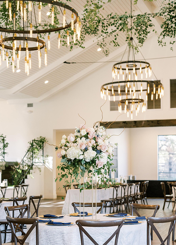 Chandeliers hanging above wedding reception tables
