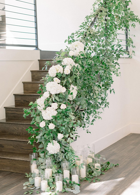 Flowers and greenery cascading down a staircase railing
