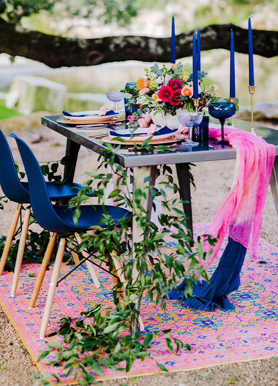 Blue chairs at reception table atop a vibrant pink and blue rug