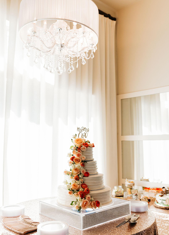 Square tiered wedding cake adorned with colorful flowers