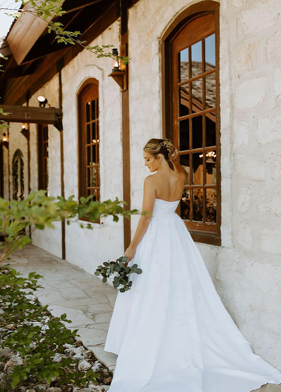 Bride with bouquet in front of wedding venue