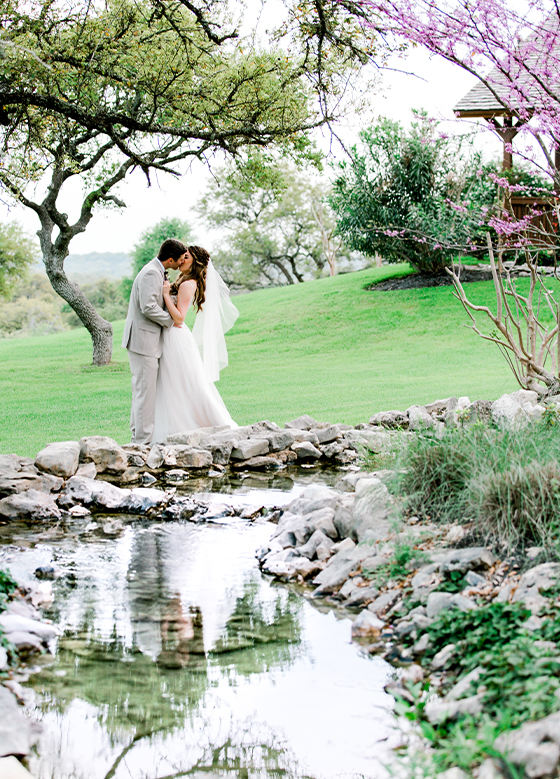 couple kissing next to water