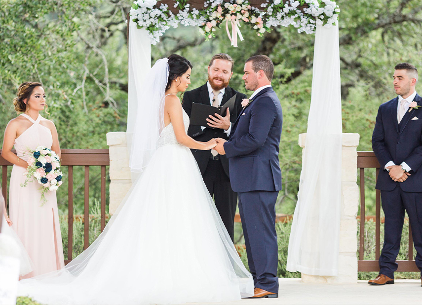 Bride and Groom Echanging Vows Outdoor Ceremony Floral Arch