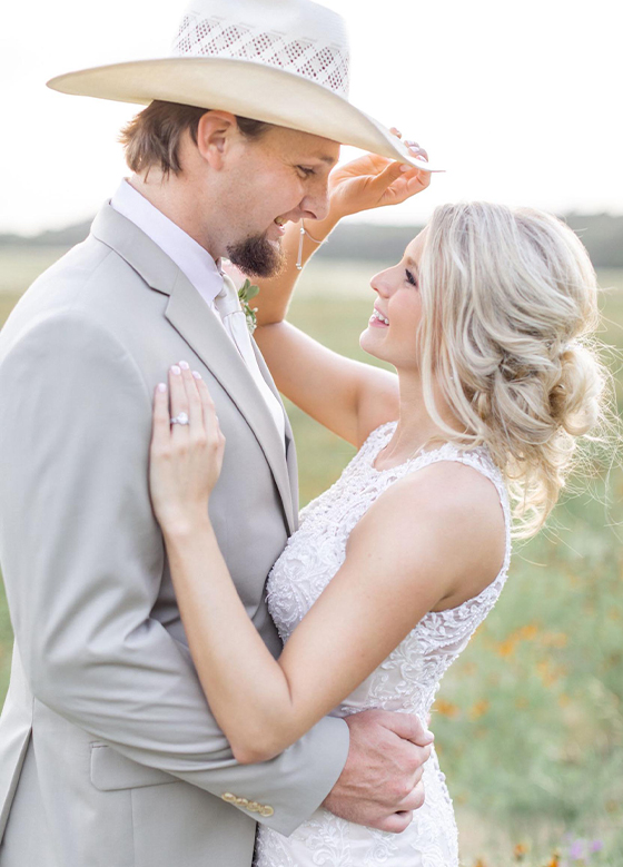 Bride Touching Grooms Cowboy Hat Embrace Valley View