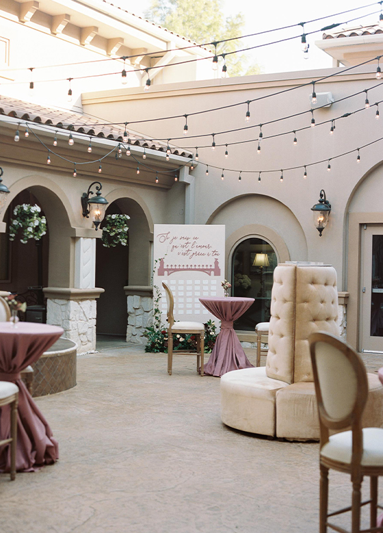 Close up of Tuscan-inspired courtyard with velvet lounge chair and bistro lights