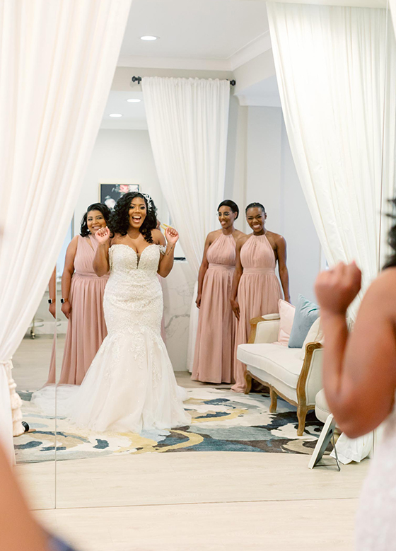 Bride first look in mirror with bridesmaids
