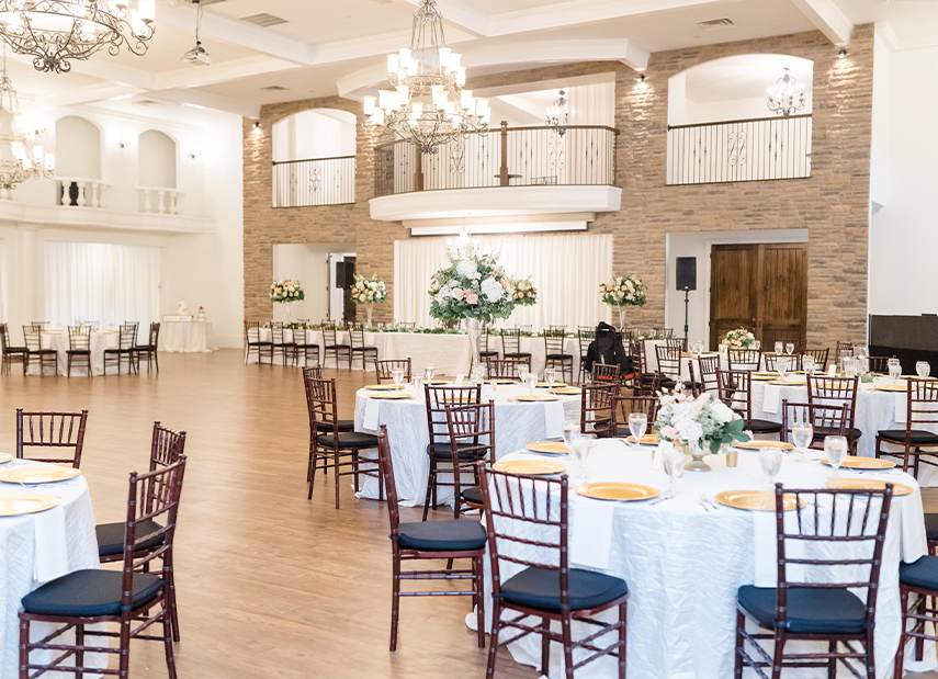 Elegant reception space with light brick walls and chandeliers