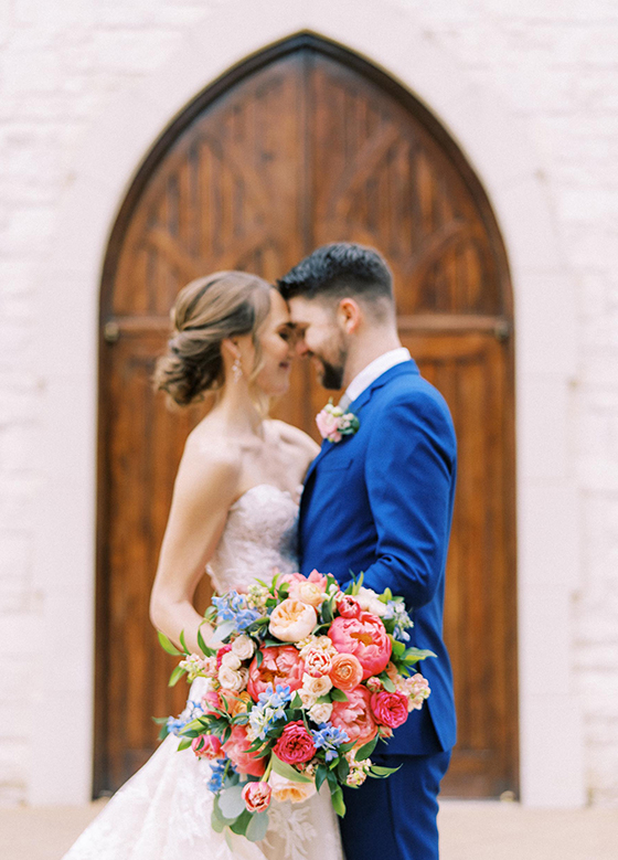 Bride and groom kissing in front of brown wood door