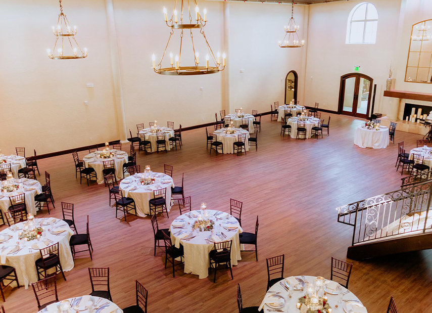 View looking down at reception space set up with round banquet tables and modern chandeliers