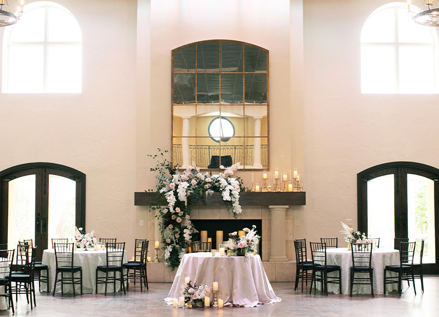 Sweetheart table in front of grand fireplace with mirror in ballroom