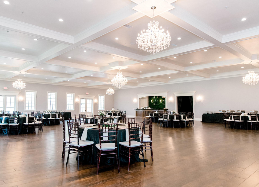 Ballroom with chandeliers and round tables with black linen